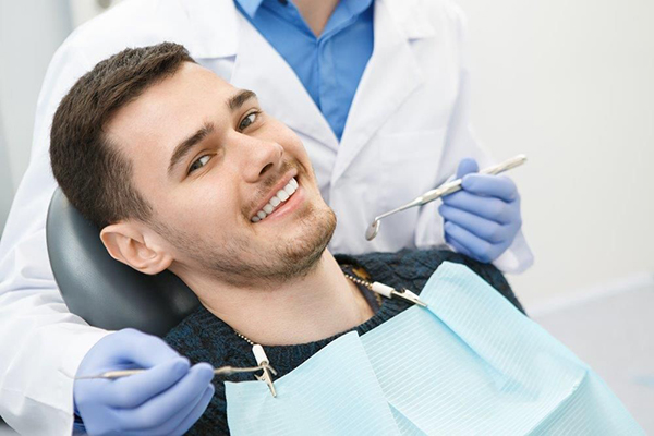 Dentist performing an oral cancer screening at Novus Dentistry in North York